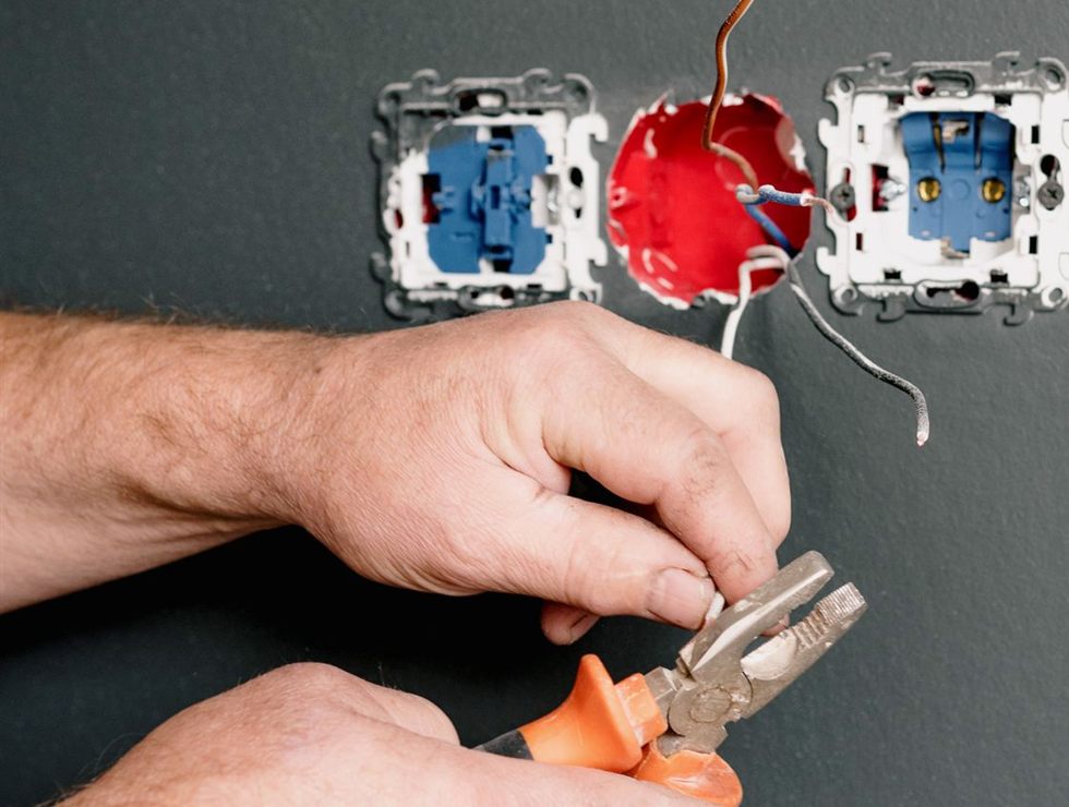 Instalação de mecanismos de tomada e interruptor em uma parede cinza